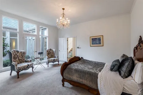 a spacious bedroom with a bed a couch and large windows