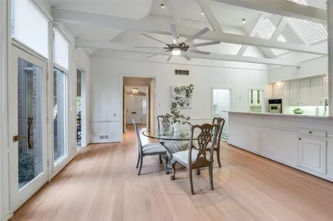 a dining room with furniture a chandelier and wooden floor