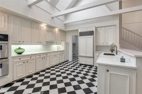 a kitchen with a sink a refrigerator and cabinets