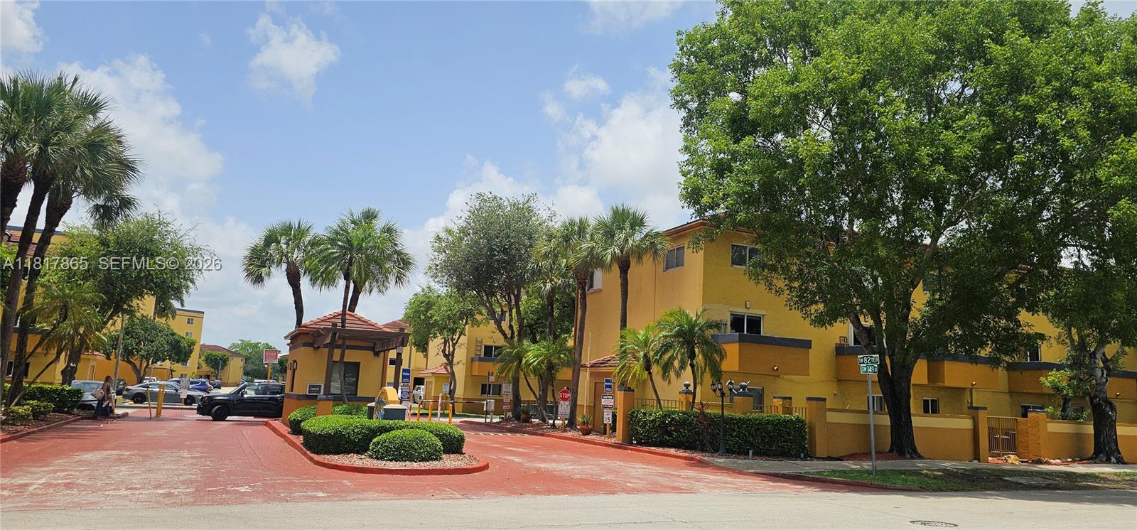 14921 Southwest 82nd Lane, Unit 19508 Miami, FL 33193 - Photo 27 of 31 a front view of a house with garden and trees