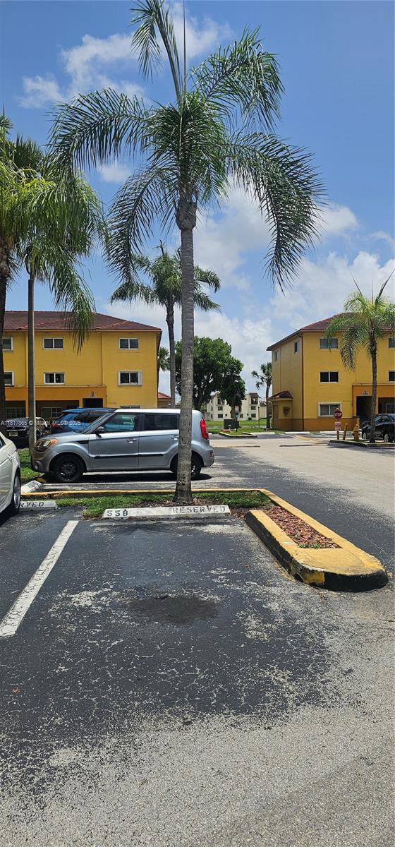 14921 Southwest 82nd Lane, Unit 19508 Miami, FL 33193 - Photo 31 of 31 a view of a backyard with a table and chairs under an umbrella