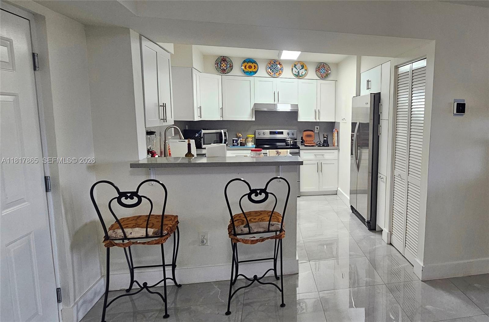 14921 Southwest 82nd Lane, Unit 19508 Miami, FL 33193 - Photo 4 of 31 a kitchen with stainless steel appliances a refrigerator a sink and white cabinets