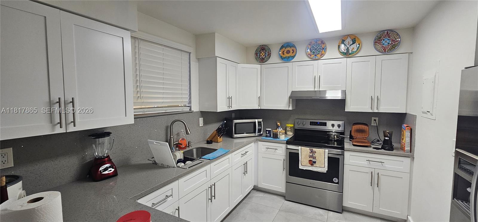 14921 Southwest 82nd Lane, Unit 19508 Miami, FL 33193 - Photo 5 of 31 a kitchen with cabinets stainless steel appliances and a sink