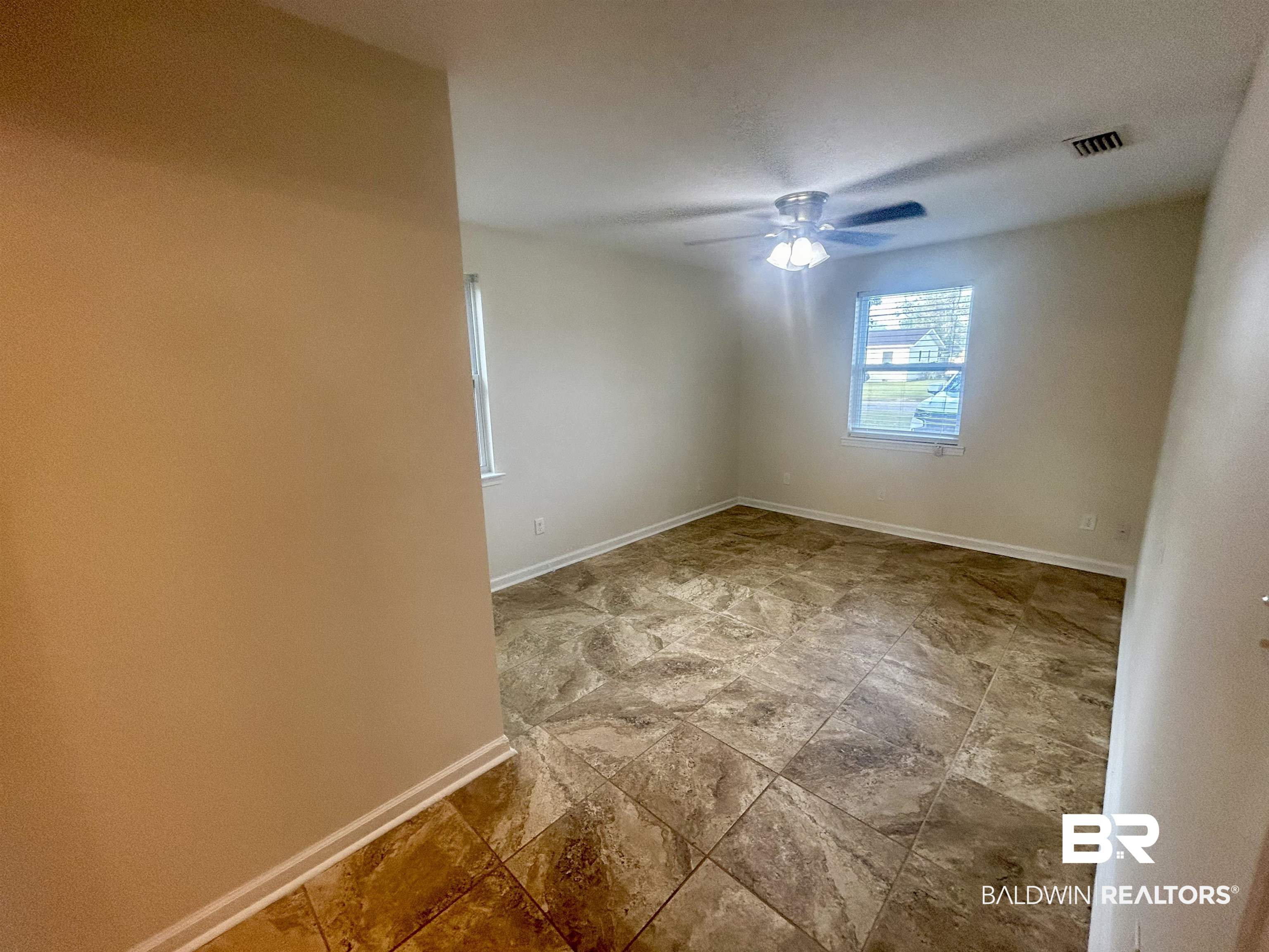 187 Van Hoosen Road Flomaton, AL 36441 - Photo 12 of 29 Empty room with light stone finish flooring and ceiling fan