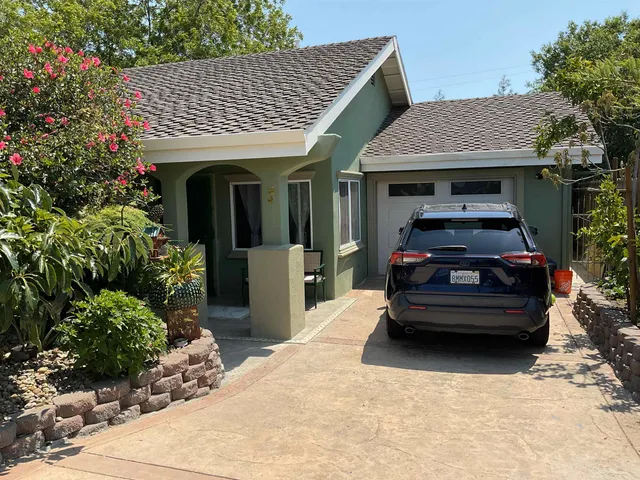 a front view of a house with a garden
