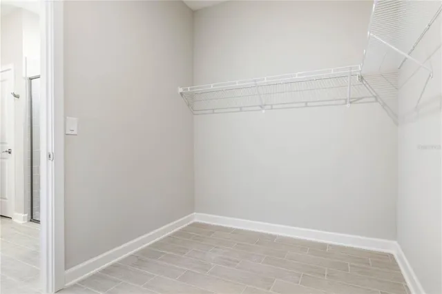 a view of an empty walk in closet with wooden floor