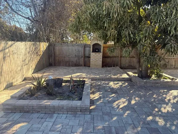 a view of a backyard with large trees and plants