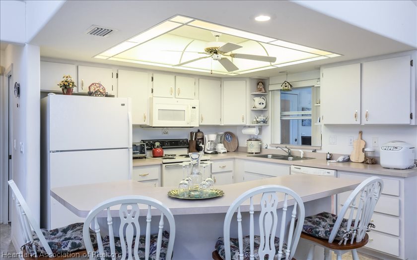 4435 Leaf Road Sebring, FL 33875 - Photo 9 of 16 a kitchen with stainless steel appliances a table and a refrigerator