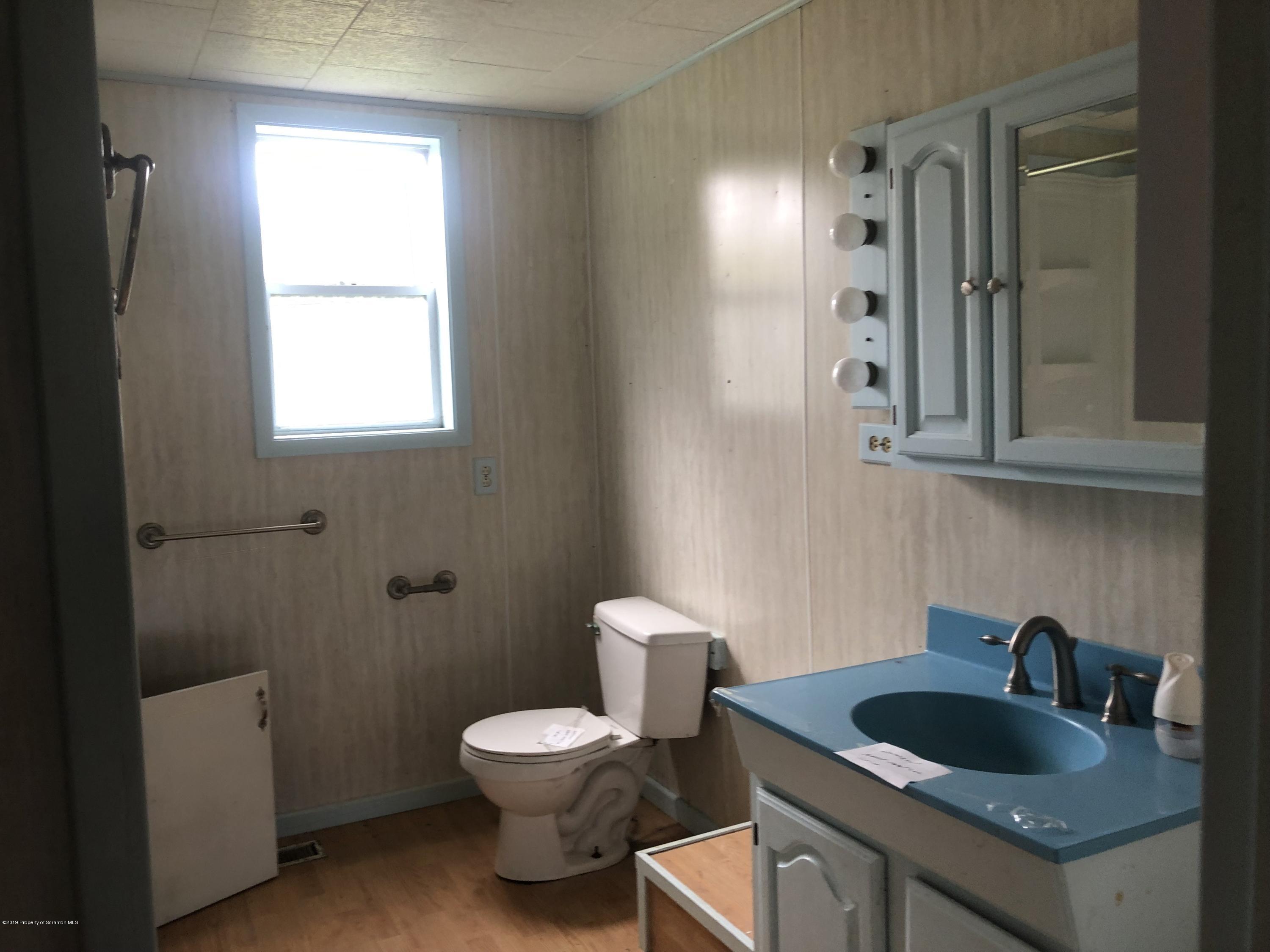 1067 Preacher Brook Road Monroeton, PA 18832 - Photo 7 of 32 a bathroom with a toilet sink and mirror