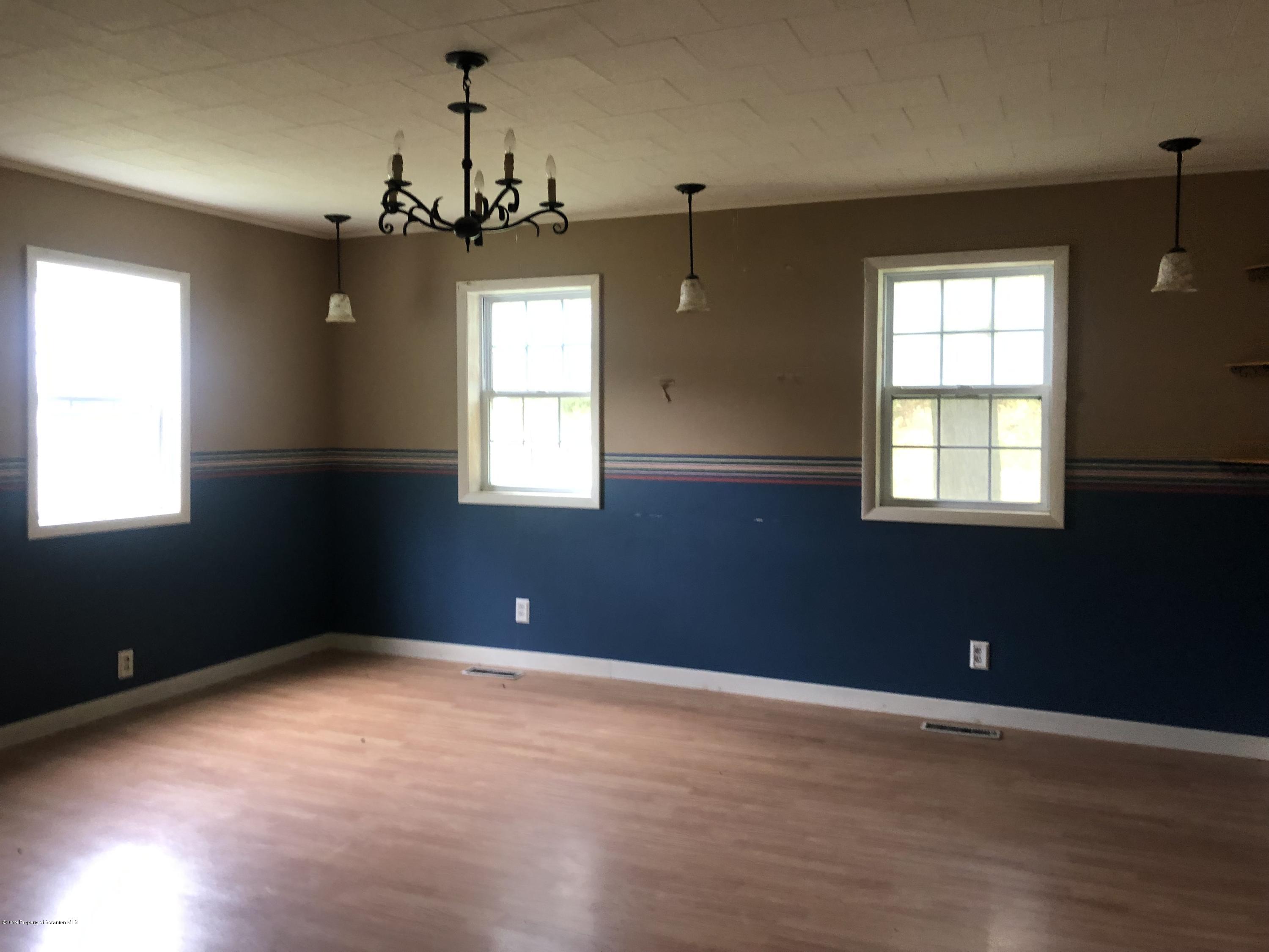 1067 Preacher Brook Road Monroeton, PA 18832 - Photo 8 of 32 an empty room with windows and chandelier