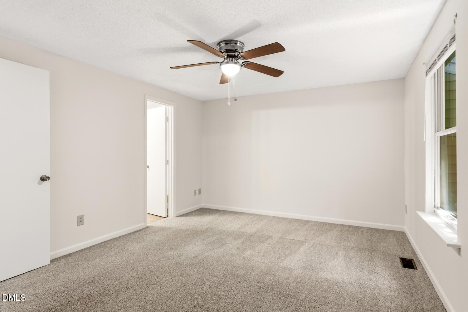 1135 Villa Green Court Raleigh, NC 27612 - Photo 11 of 17 an empty room with window and ceiling fan