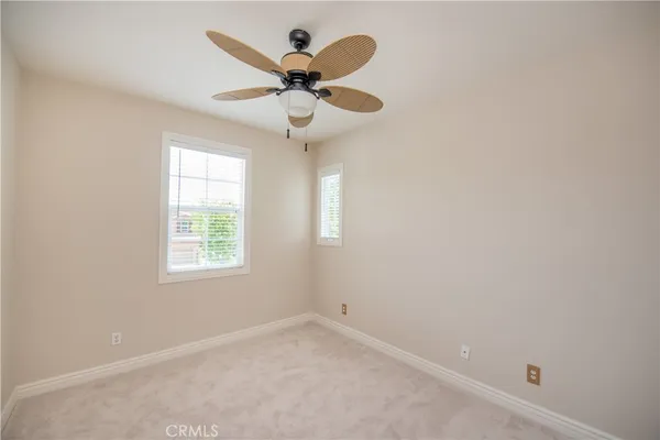 an empty room with a window and a ceiling fan