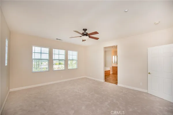 an empty room with a ceiling fan and a window