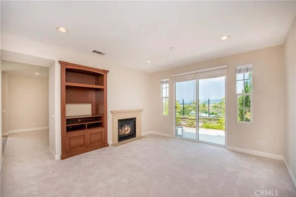 an empty room with windows and fireplace