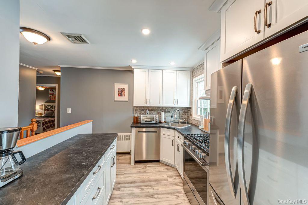 4 Hollyberry Road Plainview, NY 11803 - Photo 8 of 20 a kitchen with stainless steel appliances granite countertop a refrigerator a stove and a sink
