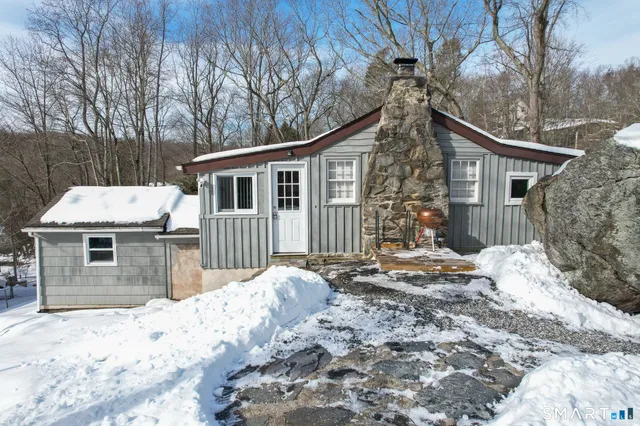 a front view of a house with a yard covered in snow