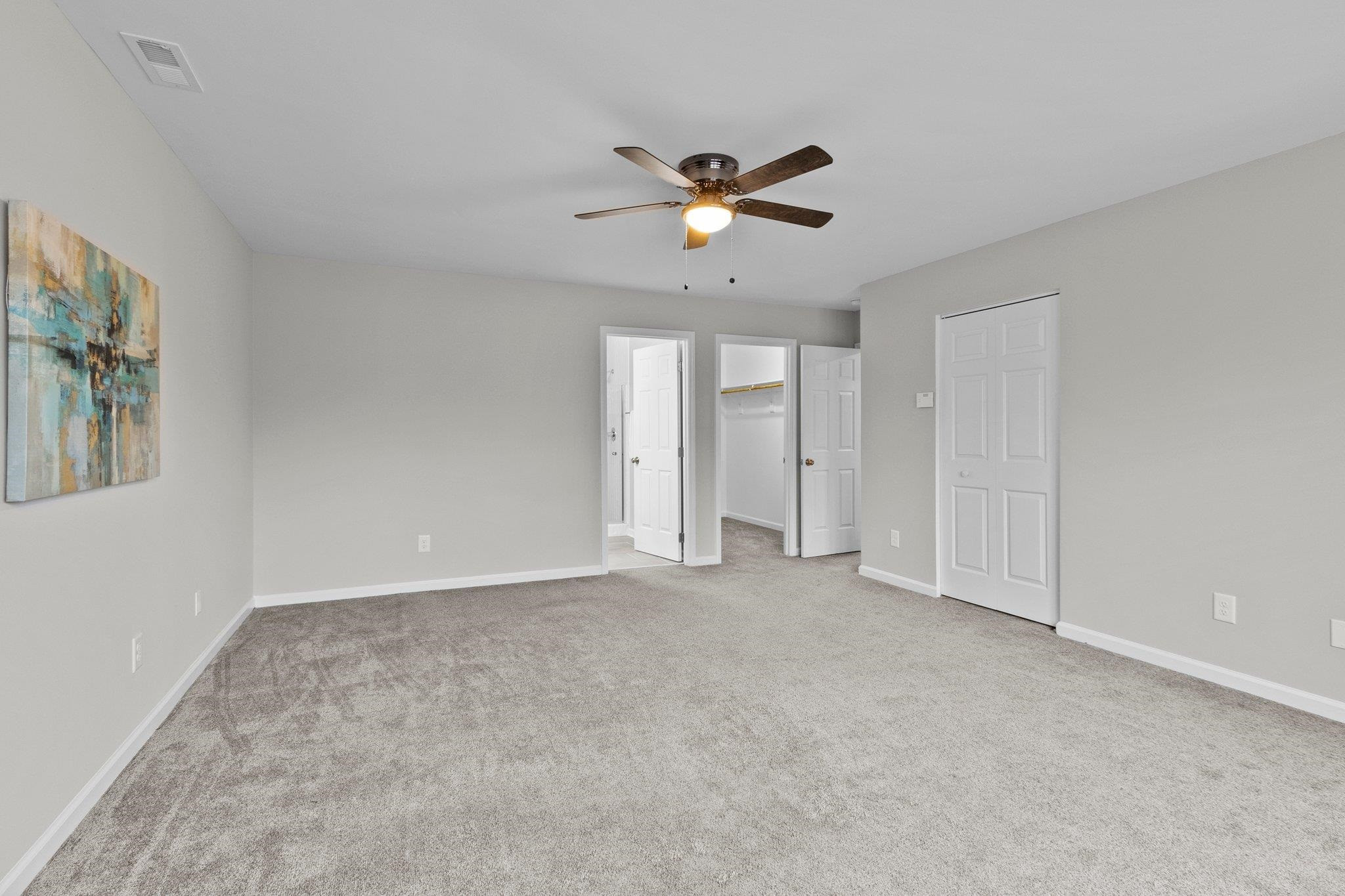 5616 Torness Court Raleigh, NC 27604 - Photo 19 of 37 Primary Bedroom has triple window, WIC, carpet, and ceiling fan. Primary Bedroom