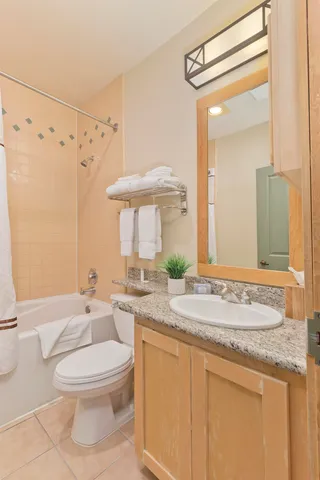 a bathroom with a granite countertop sink toilet a mirror and shower