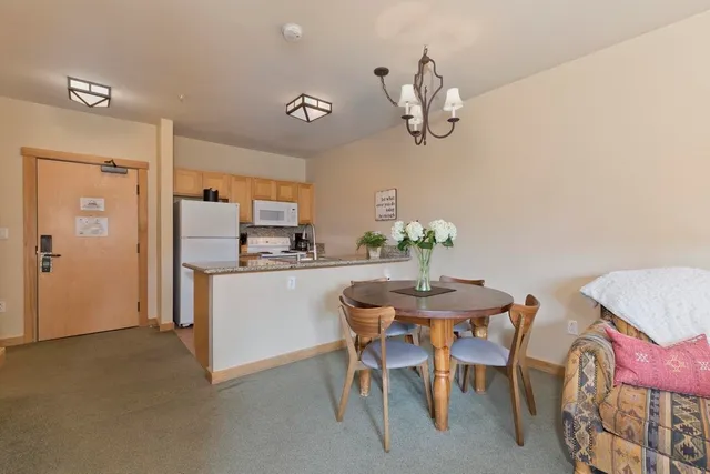 a kitchen with stainless steel appliances a table and chairs in it