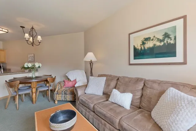 a living room with furniture and view of kitchen