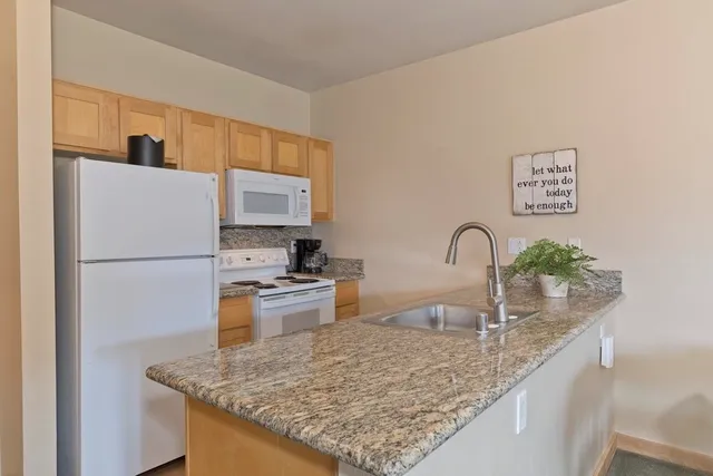 a kitchen with sink a refrigerator and microwave