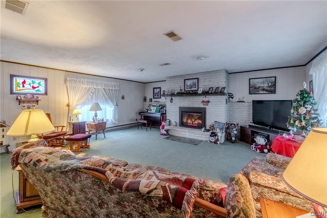 1685 Trexlertown Road Lower Macungie Township, PA 18062 - Photo 14 of 26 a living room with furniture a flat screen tv and a fireplace