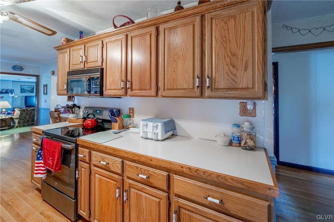 1685 Trexlertown Road Lower Macungie Township, PA 18062 - Photo 19 of 26 a kitchen with stainless steel appliances granite countertop a sink dishwasher stove and cabinets with wooden floor