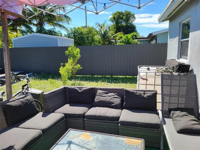 a couple of chairs and a table sitting in back yard of a house