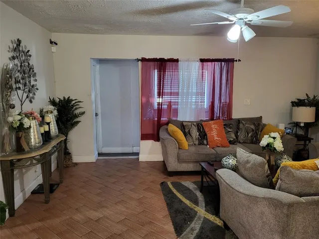 a living room with furniture a chandelier and a flat screen tv