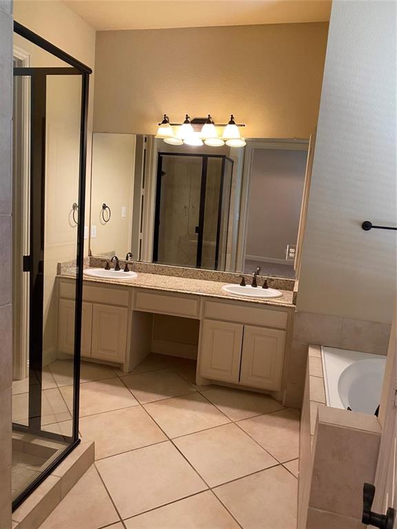 2222 Kirby Street Dallas, TX 75204 - Photo 9 of 25 Bathroom featuring a dual vanity with a light-colored countertop, an integrated soaking tub, a stand-alone shower with a dark-framed enclosure, and ceramic tile flooring