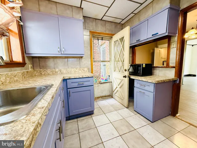 a view of a hallway with wooden floor and a bathroom