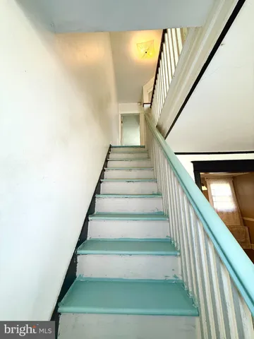 a view of empty room with kitchen and window