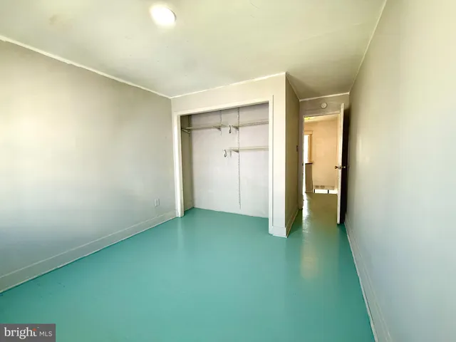 an empty room with a window and ceiling fan