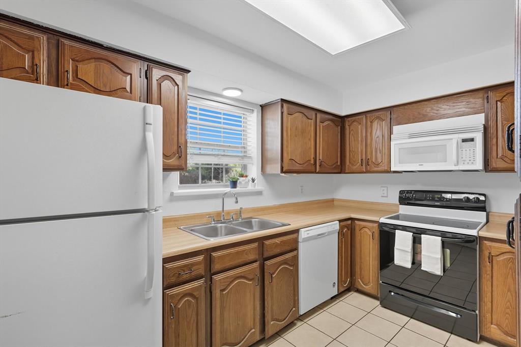 910 Turtle Cove, Unit 148 Irving, TX 75060 - Photo 17 of 33 a kitchen with a sink stove and refrigerator
