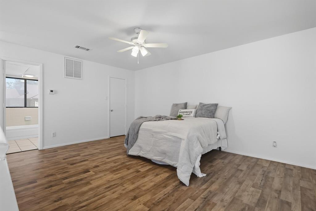 910 Turtle Cove, Unit 148 Irving, TX 75060 - Photo 21 of 33 a bedroom with a bed and wooden floor