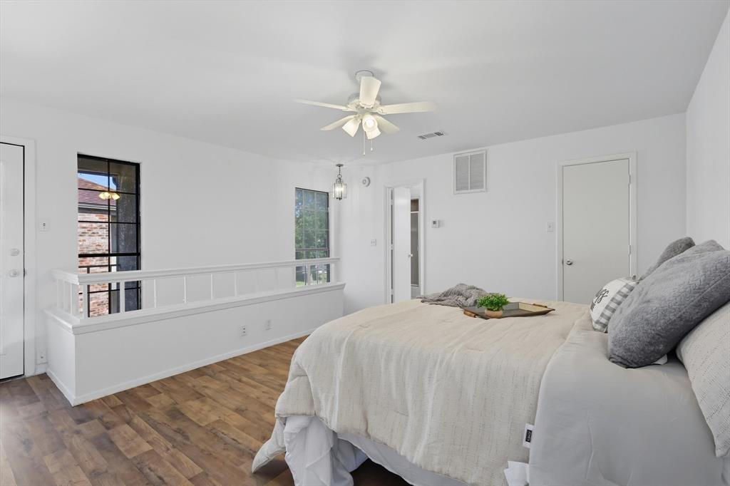 910 Turtle Cove, Unit 148 Irving, TX 75060 - Photo 22 of 33 a bedroom with a bed and a chandelier