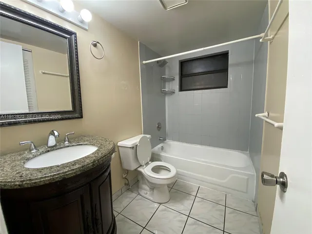 a bathroom with a granite countertop sink a toilet and a mirror