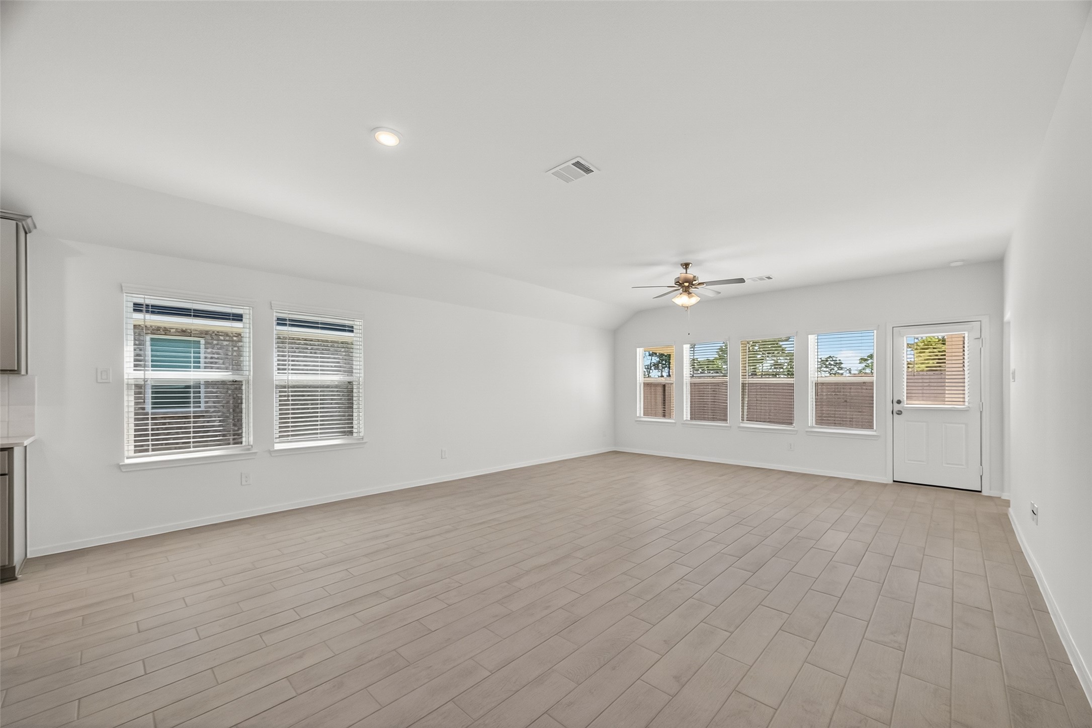 2111 Spring Hollow Drive Baytown, TX 77521 - Photo 12 of 42 an empty room with wooden floor and windows