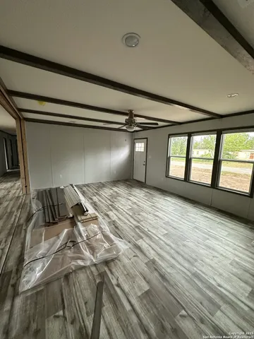 a view of a room with wooden floor and windows