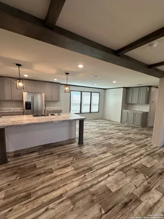 a large white kitchen with kitchen island a sink stainless steel appliances and cabinets