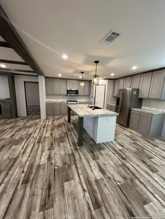 a open kitchen with kitchen island a sink stove and refrigerator