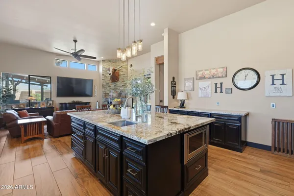 a kitchen with stainless steel appliances granite countertop a sink refrigerator and microwave