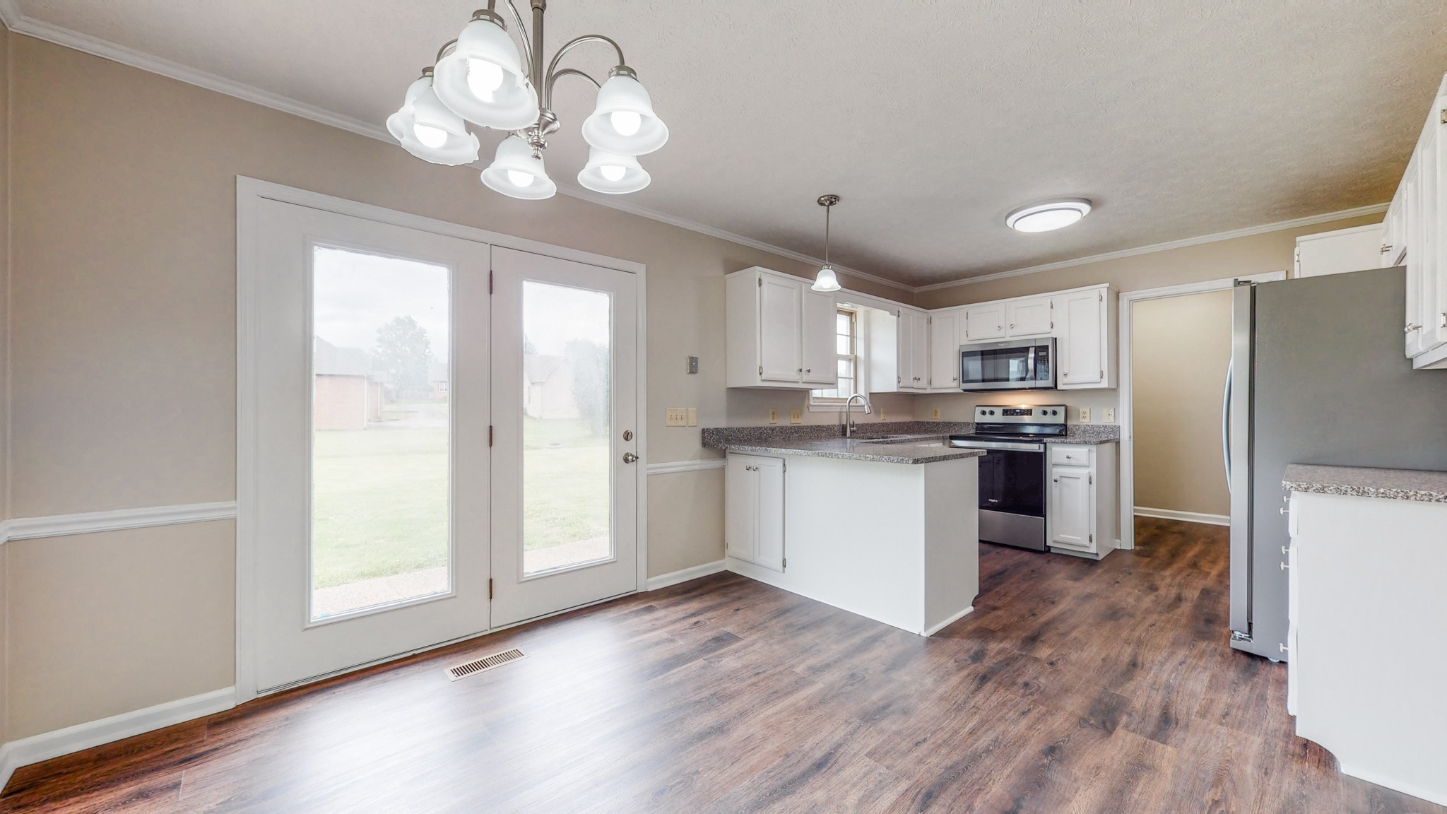 1883 Coles Ferry Pike Lebanon, TN 37087 - Photo 7 of 29 a kitchen with stainless steel appliances granite countertop a refrigerator a sink dishwasher a stove and white countertops with wooden floor