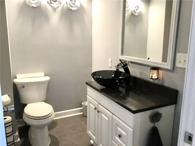 a bathroom with a toilet a sink and a mirror