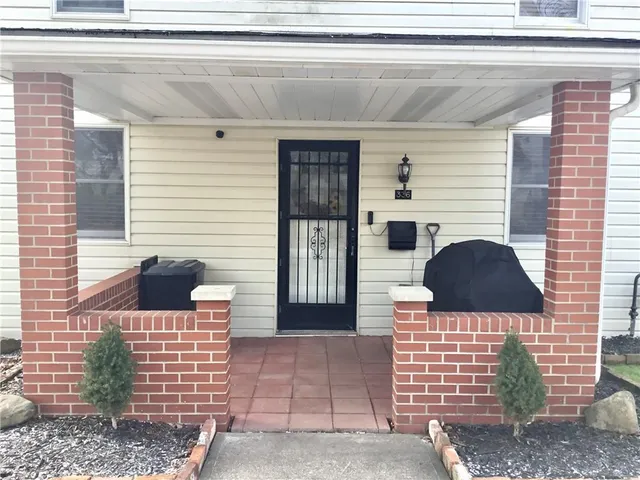 a view of a livingroom with wooden floor and a bathroom