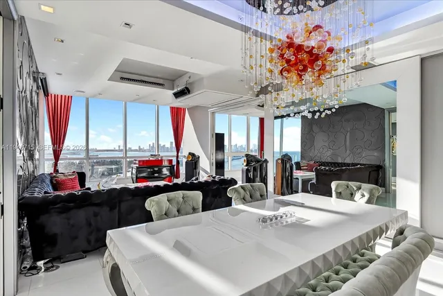 a dining area with furniture a chandelier and window