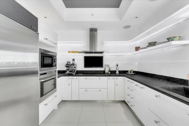 a bedroom with bed and a large mirror on the dresser
