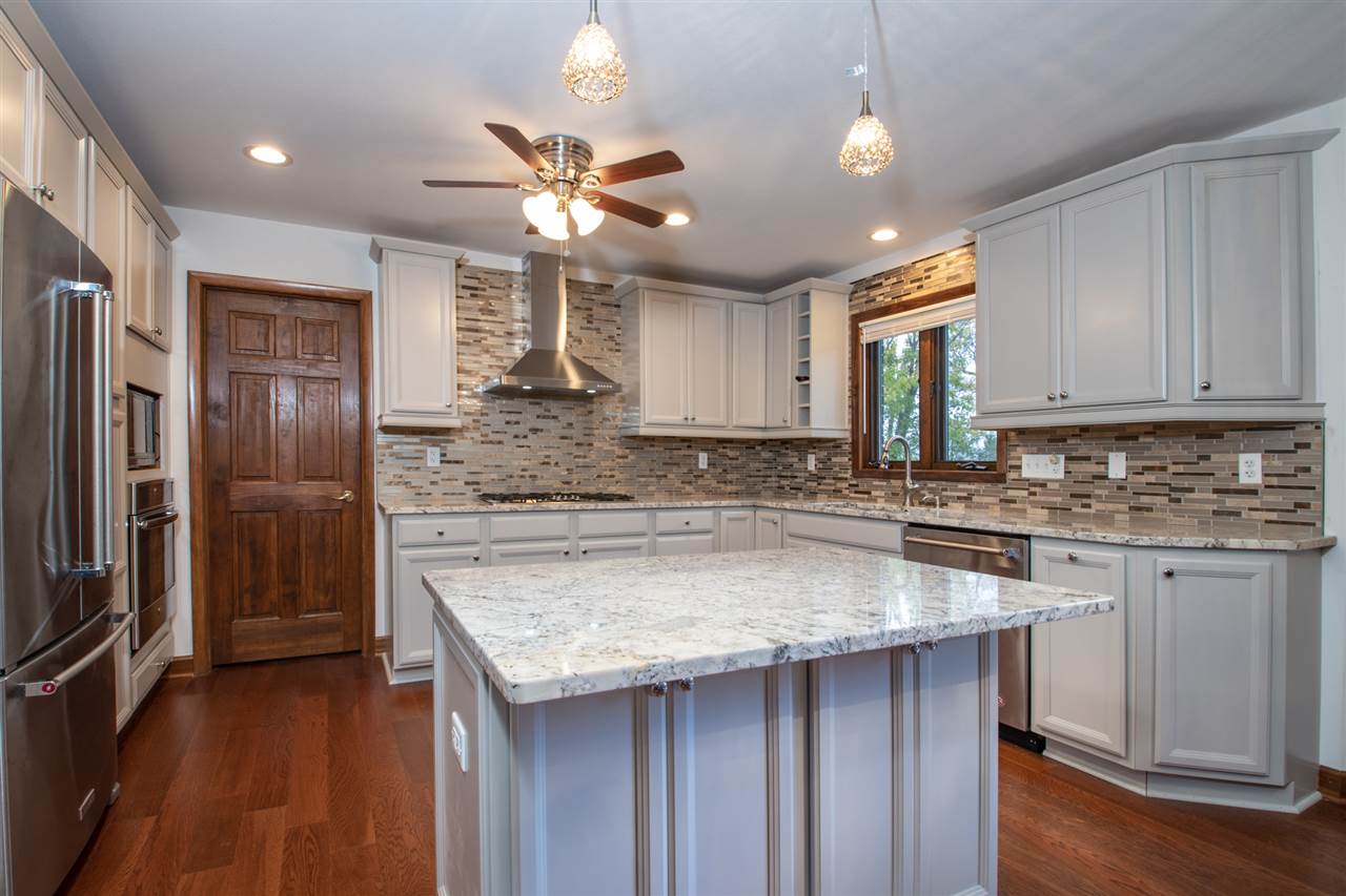 7022 Sentinel Road Rockford, IL 61107 - Photo 5 of 25 a kitchen with a center island and stainless steel appliances
