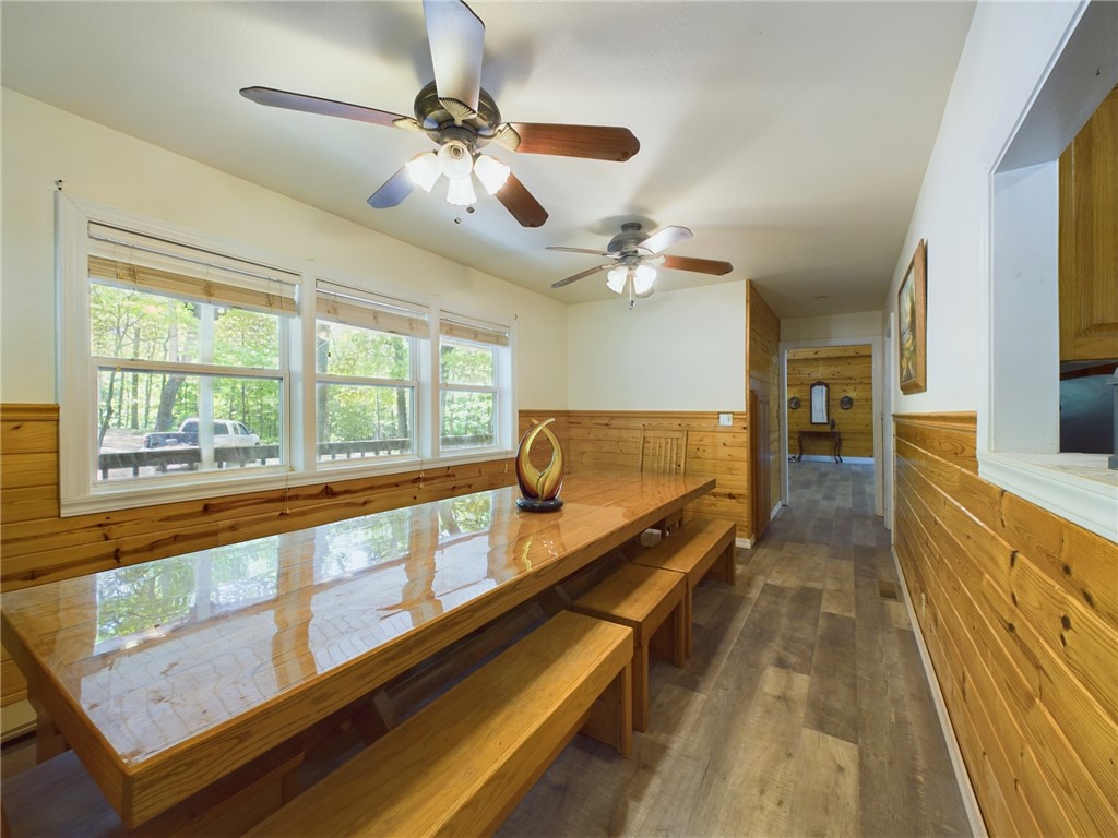 12883 Nickels Road West Fork, AR 72774 - Photo 5 of 26 Dining area featuring an expansive wood-finish table with integrated benches, natural wood paneling, and multiple windows