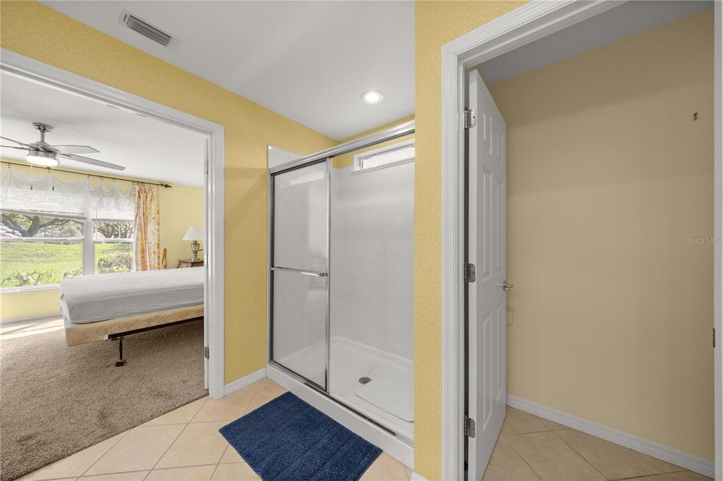 13421 Southeast 92nd Court Road Summerfield, FL 34491 - Photo 14 of 59 a bathroom with a glass shower door and a window